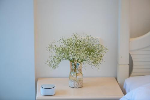 a vase of flowers on a table with a candle at 丽江慕云堂观景客栈Lijiang Muyuntang View Hotel in Lijiang