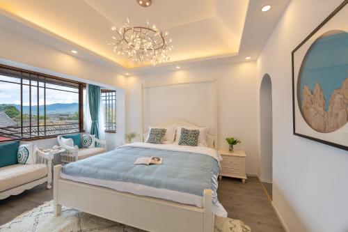 a bedroom with a bed and a chandelier at 丽江慕云堂观景客栈Lijiang Muyuntang View Hotel in Lijiang