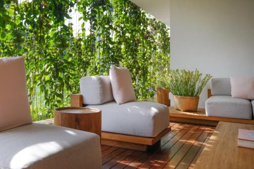 a living room with two chairs and a couch at Origin Ubud in Ubud