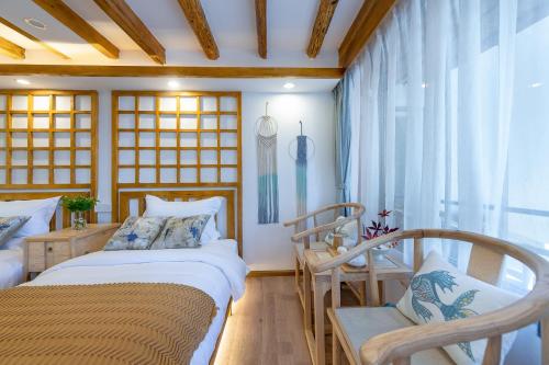 a bedroom with two beds and a chair at 丽江慕云堂观景客栈Lijiang Muyuntang View Hotel in Lijiang