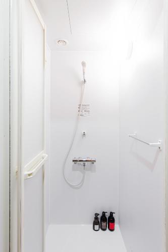 a bathroom with a shower with two pairs of shoes at Wild Cherry Blossom-HOSTEL,TOKYO KOGANEI- in Koganei