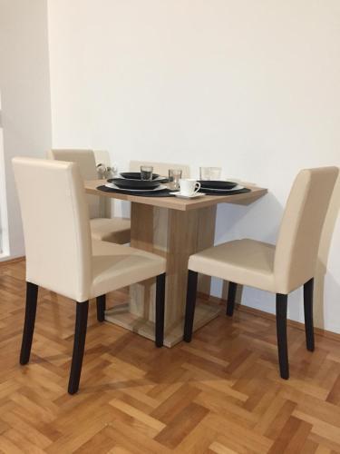 einen Esstisch mit 2 Stühlen, einem Tisch und einem Chairsktop in der Unterkunft Apartman PEŠAČKA ZONA in Šabac