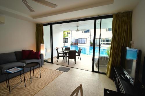 een woonkamer met een bank, een televisie en een tafel bij Sai Naam Lanta Residence SHA Plus in Koh Lanta