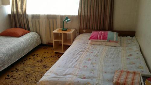 1 Schlafzimmer mit 2 Betten, einer Lampe und einem Fenster in der Unterkunft Tuule 1 Home Accommodation in Kuressaare