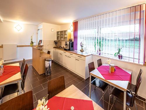 a kitchen and dining room with tables and chairs at Pension zum Bergmann in Böhlen