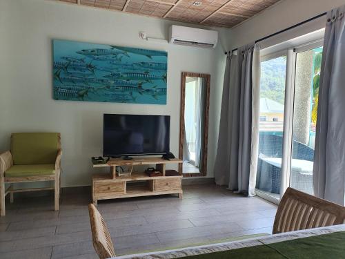 a living room with a flat screen tv on a table at Bord Mer City Apartments in La Digue
