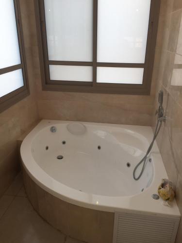 uma grande banheira na casa de banho com uma janela em נוריות בגלבוע 1 em Nurit