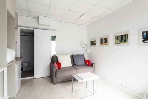ein Wohnzimmer mit einem Sofa und einem Tisch in der Unterkunft Small Is Beautiful Ideally Located Sleeps 4 in Paris