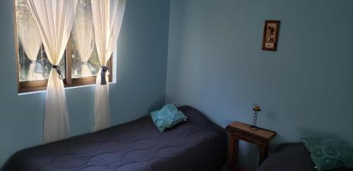 a bedroom with a bed and a window at Arquería Patagonia Lodge in Puerto Varas