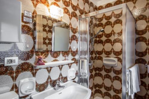 uma casa de banho com um lavatório e um espelho em Garni Edera em Corvara in Badia