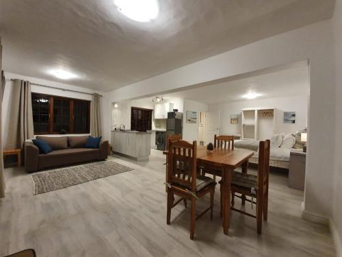 Una cocina y una sala de estar con una mesa y un sofá. en Valley View, en Plettenberg Bay