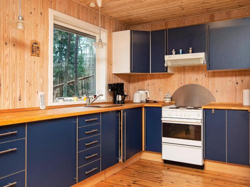 cocina con armarios azules y estufa blanca en 8 person holiday home in Frederiksv rk en Frederiksværk