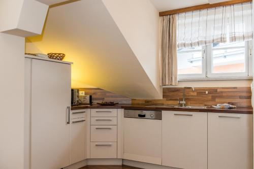 a kitchen with white cabinets and a window at Ferienhaus Elisabeth in Russbach am Pass Gschütt