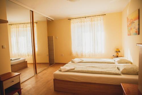 a bedroom with a large bed and a bathroom at King Arthur Panzió in Baja