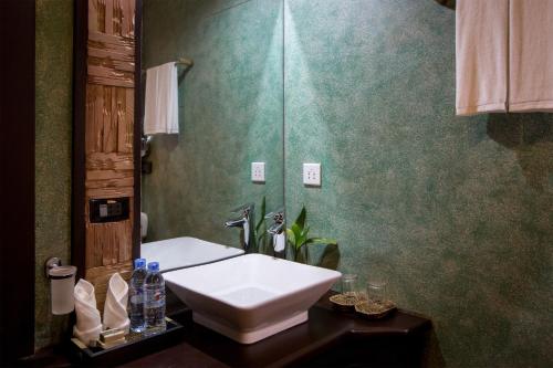 a bathroom with a white sink and a mirror at De Sarann Villa in Siem Reap