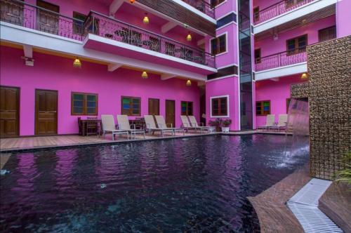 a hotel with a swimming pool in front of a building at Changpuak Boutique House in Chiang Mai