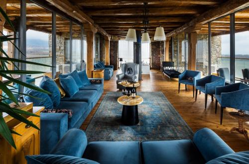 a living room with blue couches and a tv at Chateau Copsa Complex in Moskovets