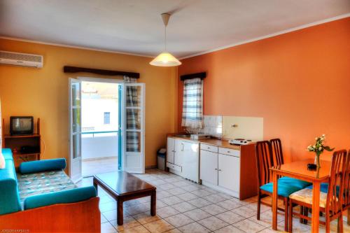 a living room with a couch and a table and a kitchen at Gryspo's Hotel in Aegiali