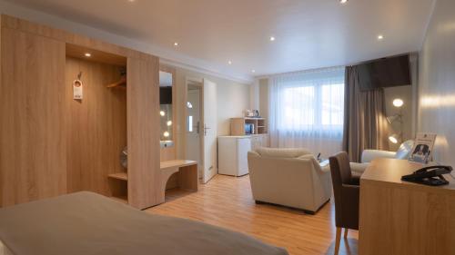a hotel room with a bed and a living room at Hotel-Restaurant Barbarossahof in Kaiserslautern