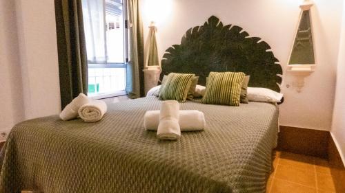 une chambre avec un lit avec des serviettes dessus dans l'établissement Wallada Casa del Indiano, à Cordoue