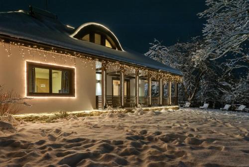a building covered in christmas lights in the snow at Chalet Hovel in Mănăstirea Humorului