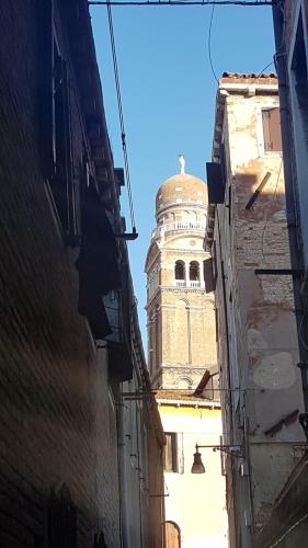 a building with a clock tower in the distance at Red House ai Mori in Venice