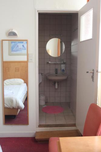 a bathroom with a shower with a sink and a bed at Hotel 2000 Valkenburg in Valkenburg