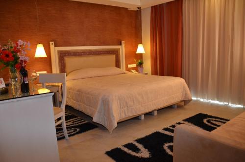 
a hotel room with a bed, table and lamps at Odysseus Hotel in Paleokastritsa
