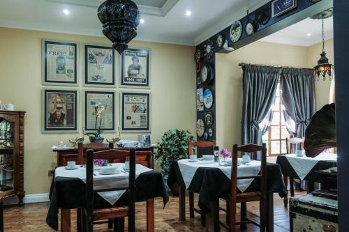 a dining room with tables and chairs and pictures on the walls at Danlee Overnight Accommodation in Polokwane