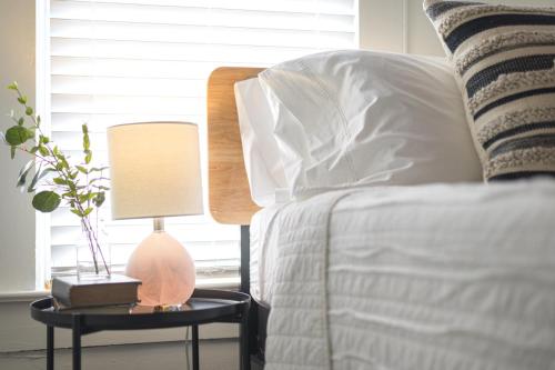 a bedroom with a bed and a table with a lamp at Restored 1930s Uptown Bungalow 2 min. to Magnolia in Waco