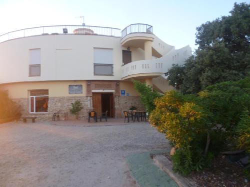 a large white building with a patio in front of it at Hotel Paraje La Lambra in Rus