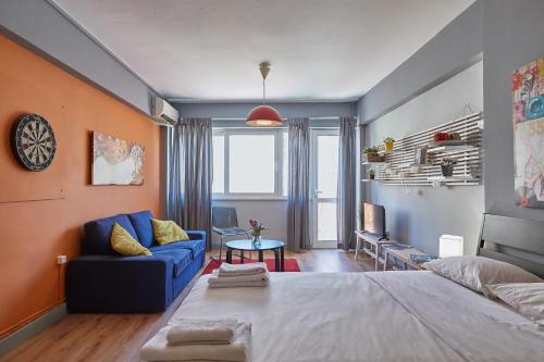 sypialnia z dużym łóżkiem i niebieską kanapą w obiekcie toStay-Unique apartment hotel in Athens center! w Atenach