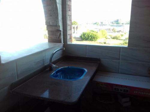 a blue sink in a bathroom with a window at Memnoun house in Luxor