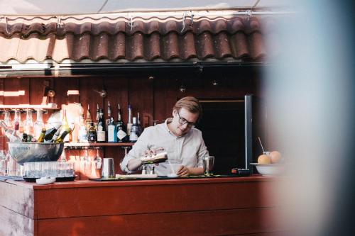 a woman standing behind a counter at a bar at Björholmen Hotell & Restaurang in Björholmen