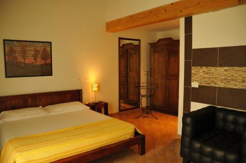 een slaapkamer met een bed en een stoel erin bij Caterina Residence in Faenza