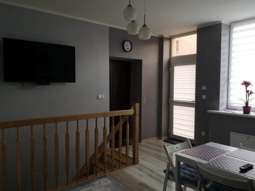 a living room with a table and a television on the wall at Apartament Detka in Nowy Targ