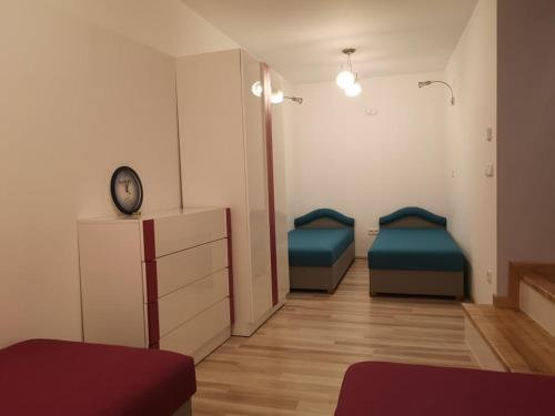 una habitación de hospital con dos camas y un reloj en Apartament Detka, en Nowy Targ