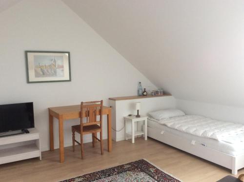 um quarto com uma cama, uma secretária e uma mesa em Haus am Wald em Waldbrunn