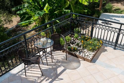 a balcony with a table and chairs and a garden at Bratis Apartments in Keri