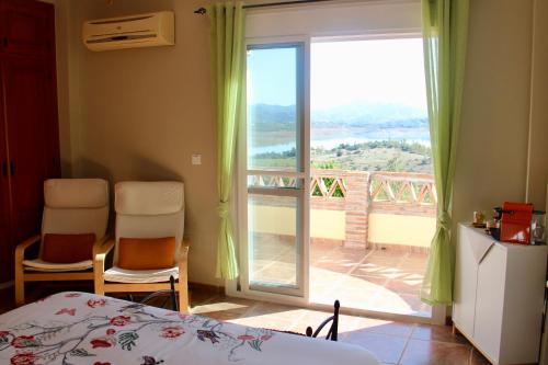 a bedroom with a bed and a view of a balcony at Casa nuestro sueño in Viñuela