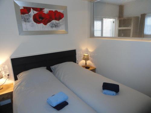 Appartement Schuitvlot في دومبورغ: غرفة نوم عليها سرير وفوط زرقاء