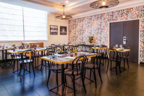 a row of tables and chairs in a room with a floral wall at Novotel Paris 17 in Paris