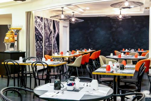a dining room with tables and chairs and a wall at Novotel Paris 17 in Paris