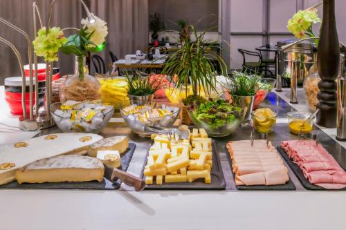 a table topped with cheese and meats and other foods at Novotel Paris 17 in Paris