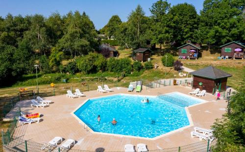 an overhead view of a swimming pool with people in it at Camping de Tauves in Tauves