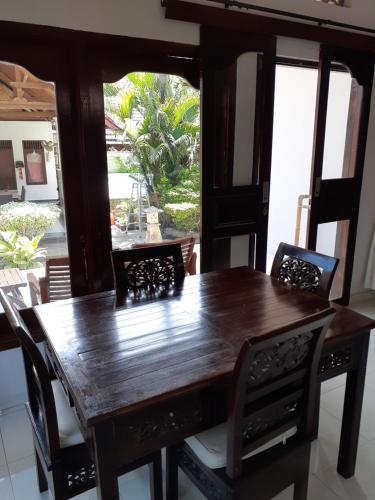 a wooden dining room table and chairs with a large window at Double One Villas Amed II in Amed