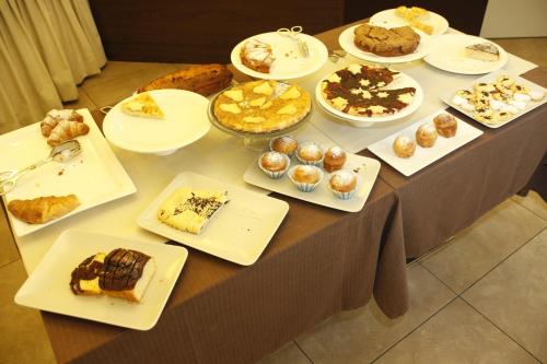 a table filled with different types of desserts and pastries at Hotel Alibi in Rimini