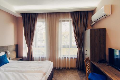 a hotel room with a bed and a window at Hotel Magura in Haskovo