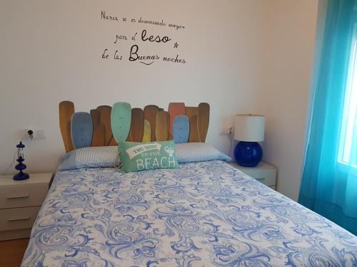 1 dormitorio con 1 cama con cabecero de madera en Apartamento Playa San Lorenzo, en Gijón