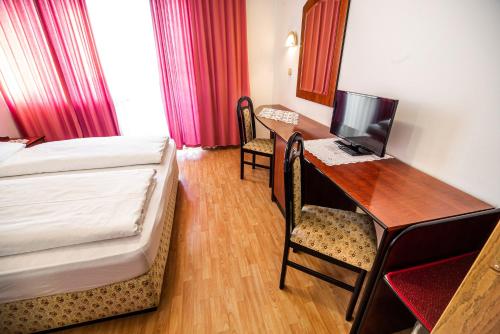 a bedroom with a bed and a desk with a computer at Guesthouse Leski Dvor in Lesce